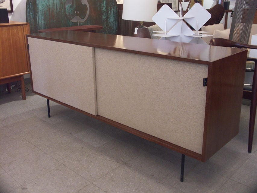 Lovely example of Florenxce Knoll's well known cabinet design. The tall walnut case, features a pair of sliding doors, each concealing two storage areas with adjustable shelves, including a divided drawer in the far left bank. Great large scale