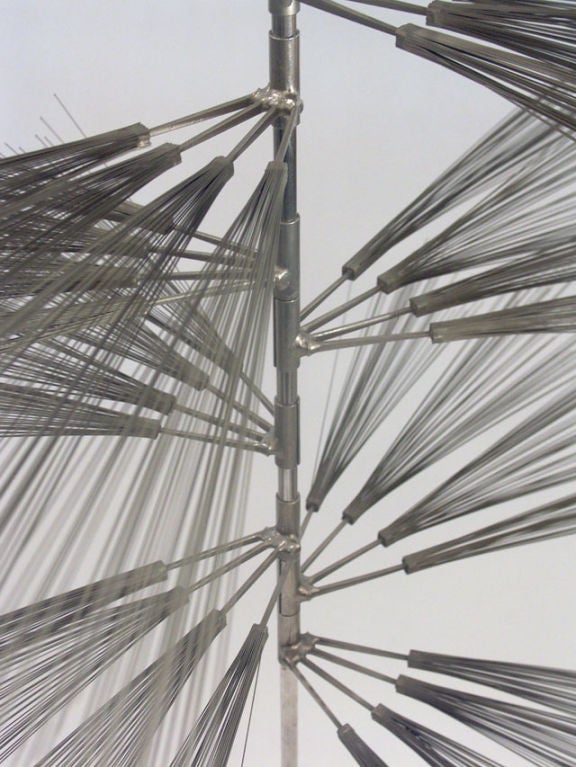 An early experimental work by Bertoia, as he investigated the influence of nature on his work. A simple cross base and stem, support a stack of 24 adjustable stainless spray branches, each composed of four carpenters nails with its own array of thin