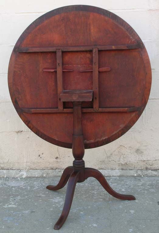 Traditional tilt-top table in mahogany. Top tilts to vertical position so that it can stand against the wall when not used (looks great against the wall too). Two wooden pins lock the top into horizontal position.

   