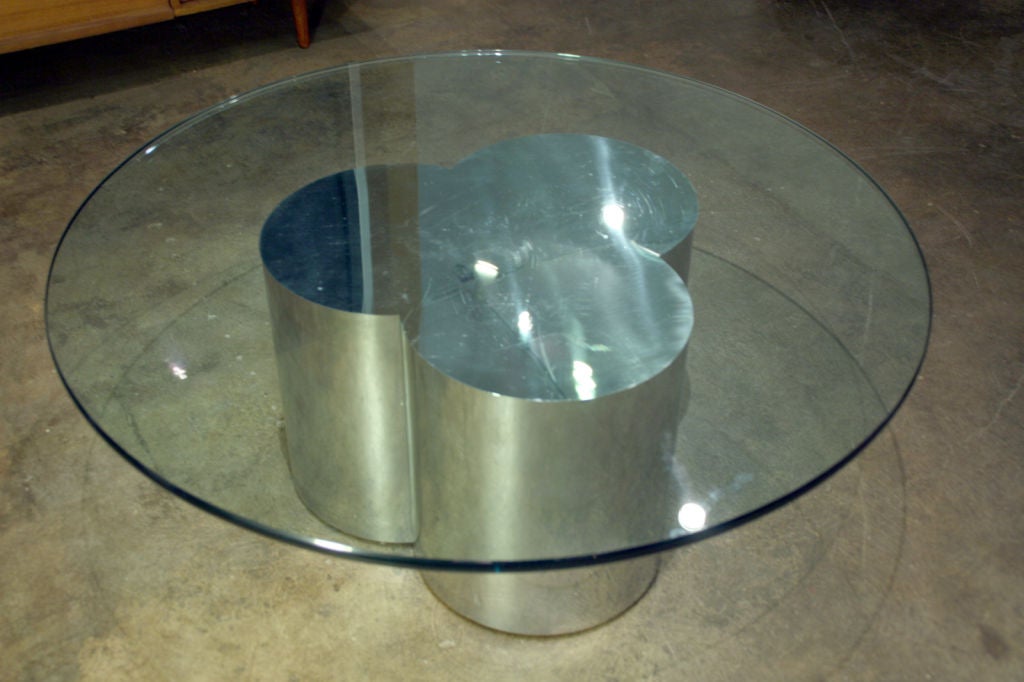 A chrome cloverleaf base with round glass top by the indomitable Curtis or C. Jere.  Base:  15 1/4