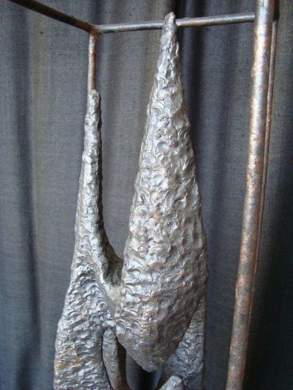 Une sculpture en bronze, biomorphique et brutale. Encadré par une cage en bronze de même texture. Une forme étonnante.
