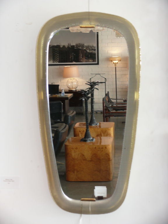 Great mirror by Mathieu Mategot in his signature perforated metal - newly plated in polished brass.  New mirror that is back lit and professionally rewired.