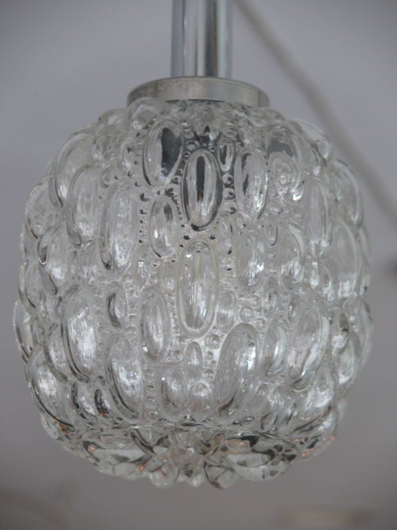 Pair of clear glass globe lights with bubble texture and chrome hardware. Priced as a pair.