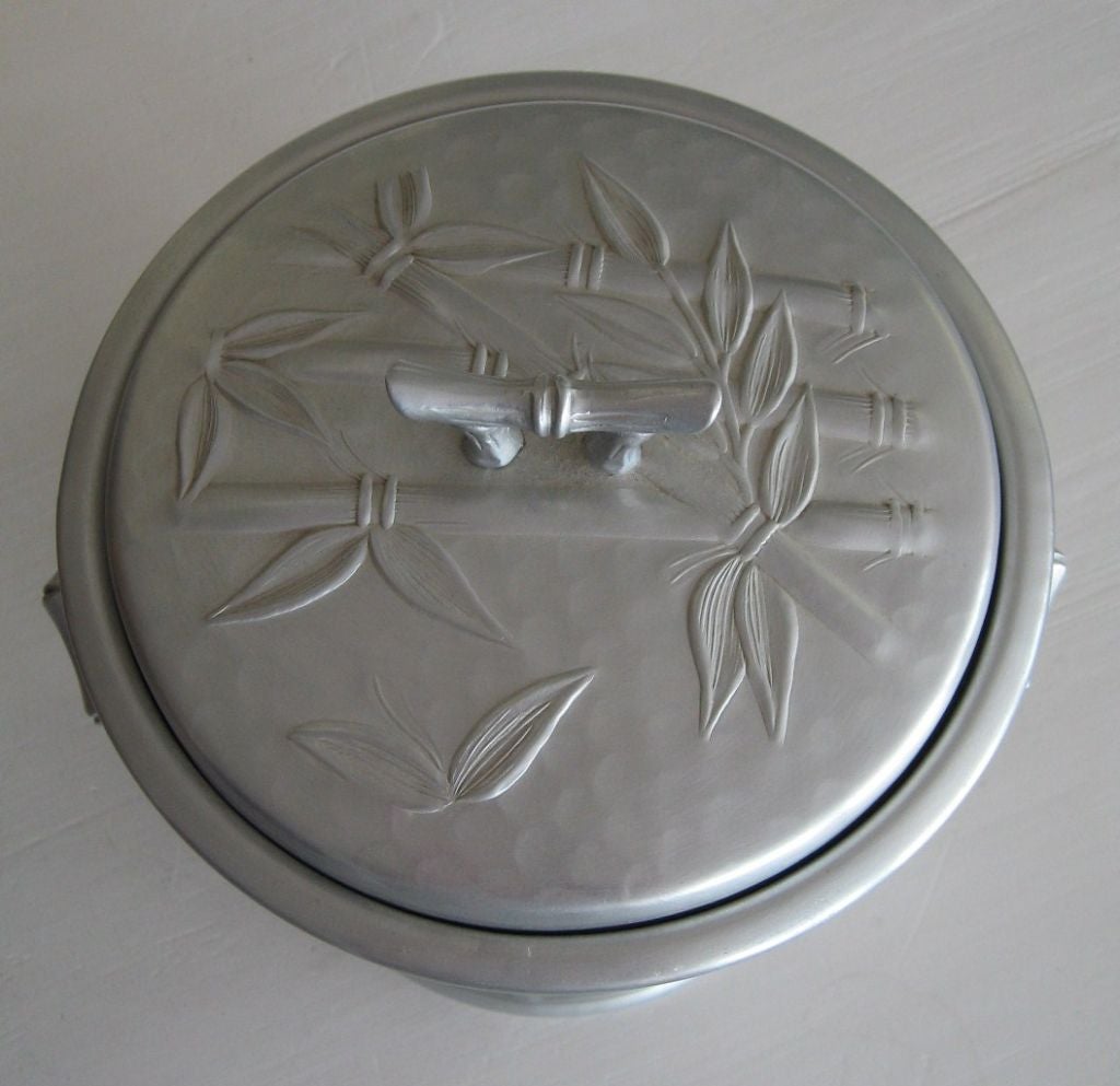 Late 40's ice bucket by Everlast, rendered in forged aluminum with a silvery satin finish. Rendered in a bas relief bamboo motif, complete with original ice scoop. This item shows as new, and was apparently never used. 24 HOUR HOLD ONLY