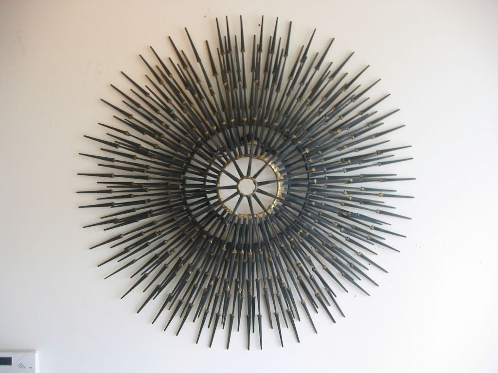 Multi dimensional wall sculpture in brutalist design using flat head nails welded together and gold painted at the seams.