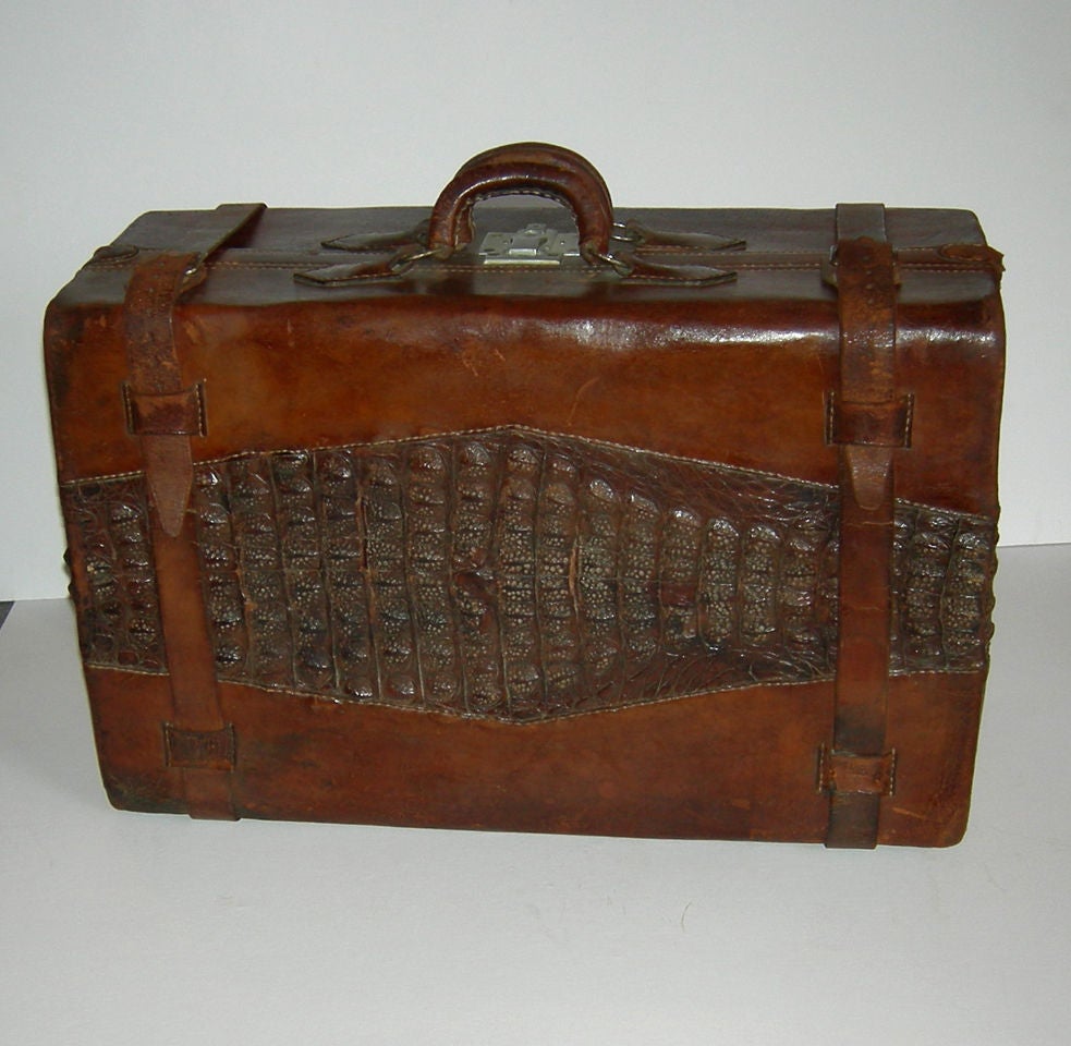 Travel used to be so stylish! This lovely bag is a combination of alligator hide and leather, with a peacock patterned interior. The design is enhanced by the pair of leather 