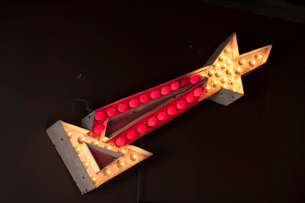 iconic lighted arrow sign<br />
red and white bulb<br />
star detail at end <br />
metal frame, dimensions approximate