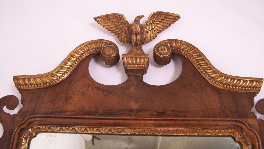 Mahogany and Parcel Gilt Chippendale Style Mirror with Broken Arch Pediment flanking a carved spread winged eagel.  Mirror plate framed with a gilt egg and dart inner frame.
American, Circa 1920.