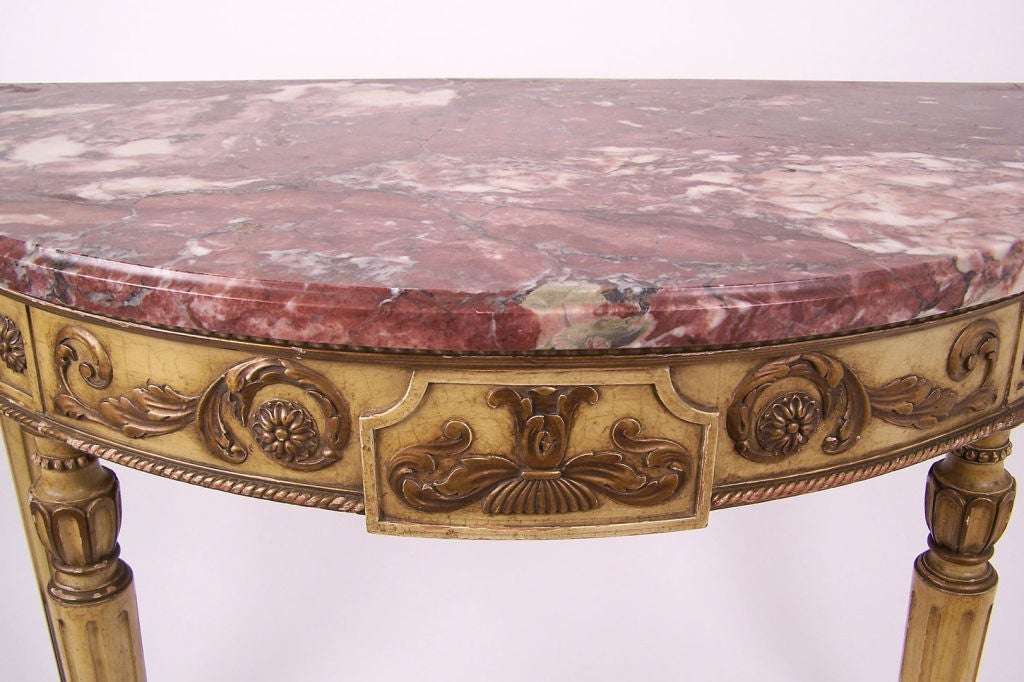 Louis XVI style rouge marble-top demilune table with acanthus leaf carved apron standing on stop fluted legs, French, circa 1880.
    