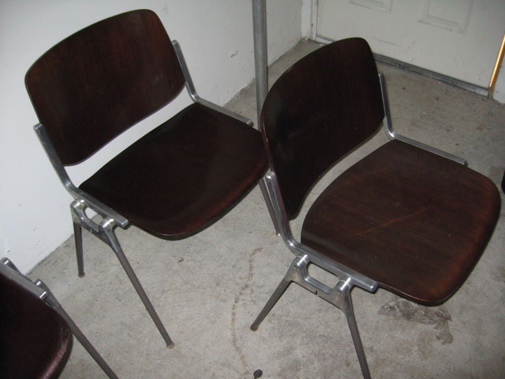 Industrial metal and brushed aluminum framed chairs with plywood seats.Chairs stack vertical.