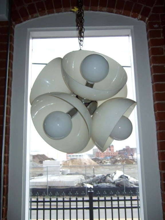 A striking and truly modern light.  Five half globe lights come together to form a large white flower or globe light.  A chrome ball in the center holds the half globes together.