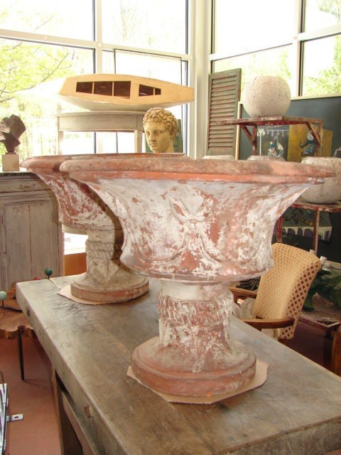 Pair of impressive terracotta urns, fleur-de-lis design, white wash paint.