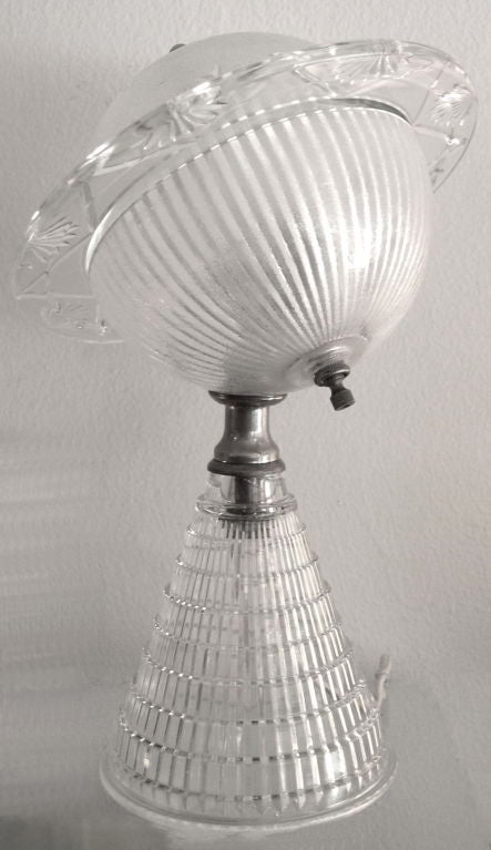 This rare lamp was made in the 1930's. It is clear glass with star and planet designs molded into the top section of the lamp. The top lifts off to change the bulb.