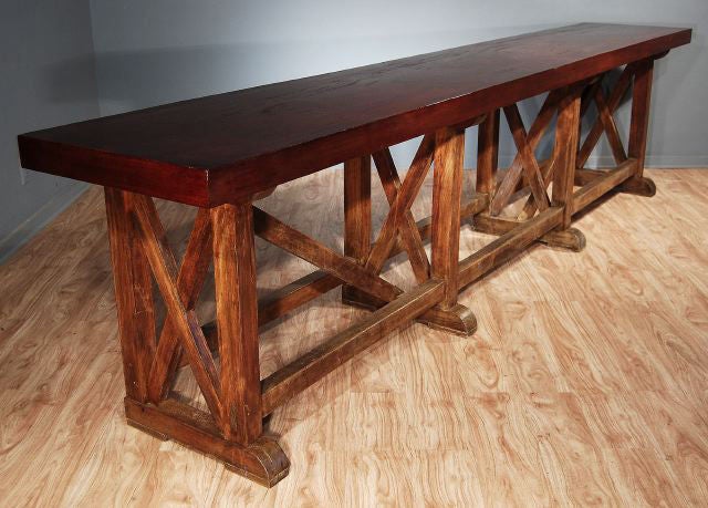 the thick rectangular top raised on square legs joined by X-formed supports and long stretchers with angled stretcher supports at each end, raised on bracket feet.