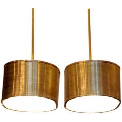 Pair of oval brass and glass cylinder hanging lights