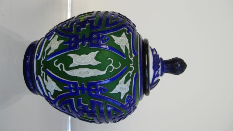 Four color incised design Peking glass ginger jar with top. Colors are cobalt blue, white, yellow and green. Peking glass is a technique where they layer glass and hand carve which was very popular in the 18th and 19th centuries.