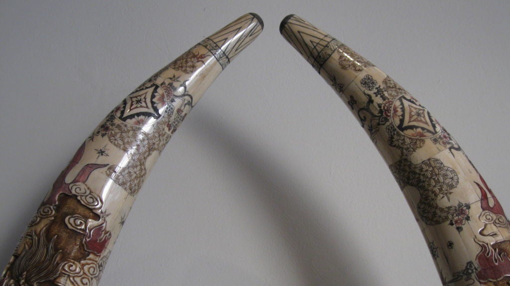 Pair of elaborately hand carved bone tusks with great detail. Mounted on bone bases.