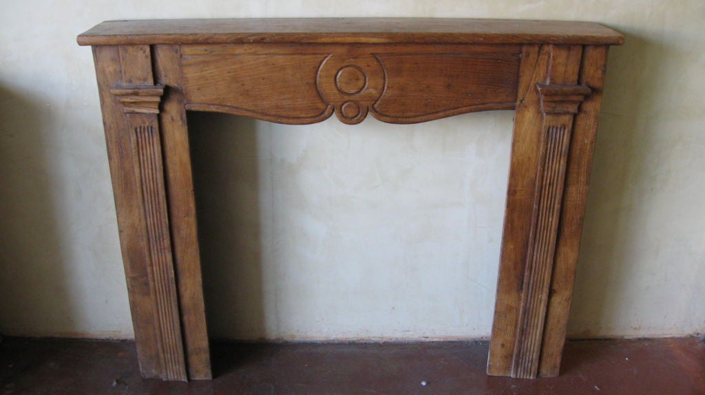 A FINE WALNUT REGENCY FIREPLACE MANTLE. WITH CARVED COLUMNS ON EACH SIDE. THE TOP MOULDED SHELF IS DECORATED WITH CURVED CARVED DETAIL.