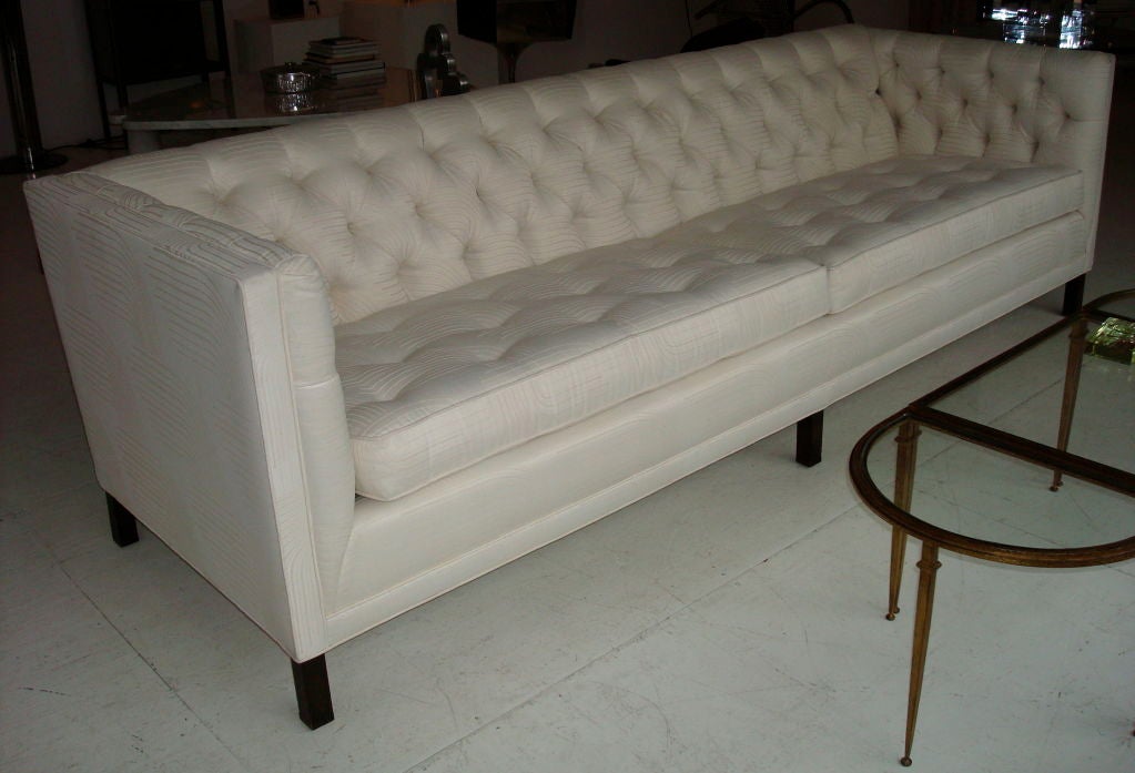 Tuxedo style sofa.  Elegant, tufted 8' long sofa, recently reupholstered in a white on white silk/cotton fabric, on ebonized feet attributed to Baker or Dunbar. Very comfortable, clean and crisp lines.