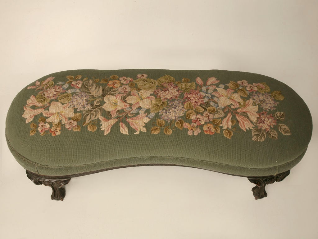 Exquisite antique English Chippendale kidney shaped bench with it's original needlepoint upholstery, a beautifully carved apron and ball and claw feet, too. This is an extraordinary bench perfectly suited for the end of a bed, a entry foyer, or