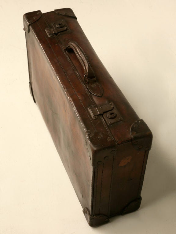 This all original antique Irish leather suitcase has a wonderful time-worn patina. In nice condition, we purchased it with the idea of building a stand, making it into a neat coffee or end table. Our shop, is so busy that we haven't had time,
