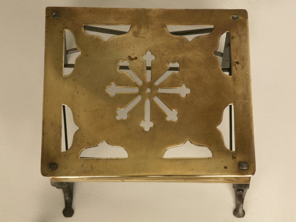 Antique English brass Victorian era footman. This stunning example is as highly decorative as it is useful indoors or out, as an awesome plant stand, footstool, or low cocktail table next to a favorite chair. Originally utilized as a teapot stand
