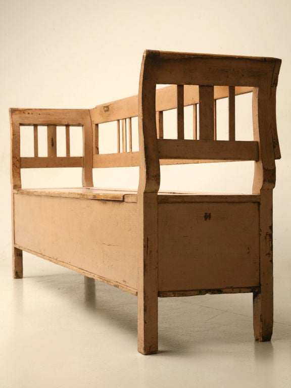 Outrageous original paint antique Continental box seat settle. Perfect utilized in an entry or backhall, hiding dirty, mucky wet shoes and boots cleverly under it's hinged seat. It's original painted finish of a soft salmon color shows years of use.