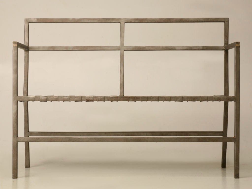 Interesting vintage American steel factory bench with an open back, open arms, and a unique woven metal seat. A phenomenal find, this beautiful bench offers clean uncluttered lines, and is surprisingly comfortable, too. Utilize this fascinating