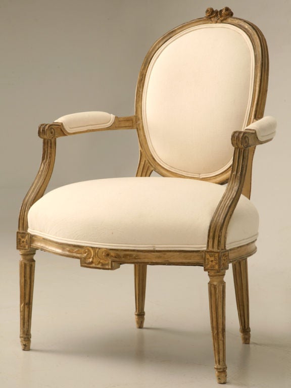 Phenomenal antique French Louis XVI style armchair with original paint, traces of the original gilding and the original patina. This chair is fantastic, the proportions are great, it is quite comfortable, and it's appearance is unbelievable. Perfect
