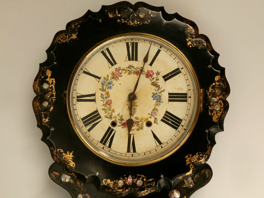 Opulent antique English papier mâché wall clock with outstanding gold and mother of pearl decorations. Not only is this phenomenal clock a functional timepiece, it is also a fabulous work of art. With beautiful scalloped edges, hand applied gilt and