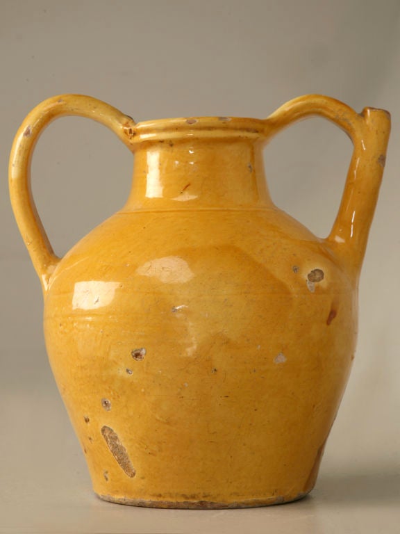 19th century French glazed earthenware water jug with it's spout ingeniously incorporated into one of it's handles. This jug is a good example of what was once a commonplace household and utilitarian object. Hand-thrown and pot-bellied with pleasing