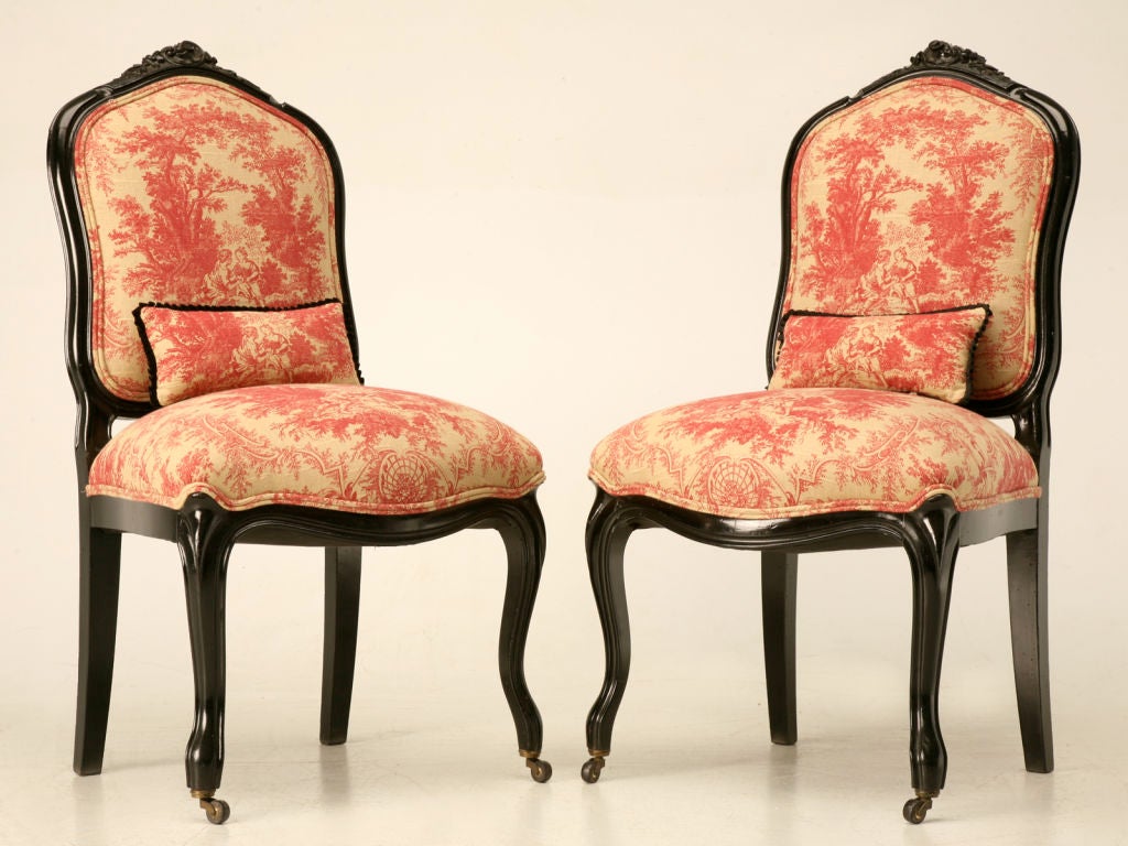 Exquisite pair of antique French Napoleon III sidechairs on casters with new contrasting red and ecru toile upholstery. These chairs have been completely restored with tightened frames, new springs, paddings and upholstery. Totally awesome, they