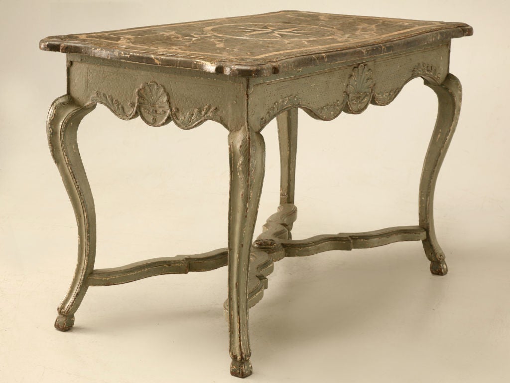 Magnificent original Italian restored paint center table with a great faux marble top. The details on this table are spectacular, from the grotto inspired apron carvings, and the graceful paw adorned legs joined by a scalloped cross-stretcher, all