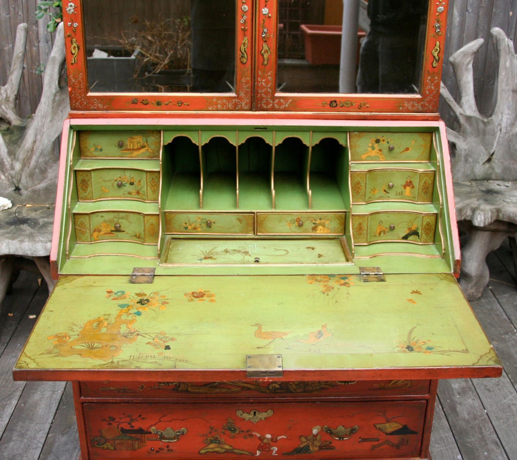 An English Queen Anne style painted fall front two-part secretary desk. The upper section having two mirrored doors with reverse carved detail in glass, surmounted by shell motif. The lower section having drawers supported by bracket feet, having