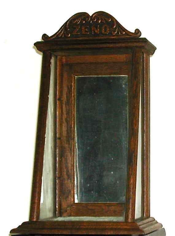 A country store display cabinet, complete with three glass shelves (not shown). This oak cabinet has the original velvet stage base, mirrored back door entry and carved marquee. A hard to find example of early advertising and point of sale diplay.