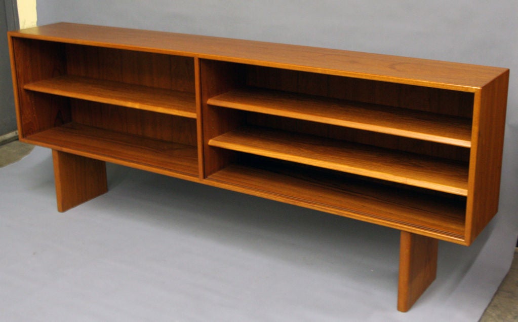 A Pair of Norwegian long low teak bookshelves with a raised box containing three adjustable shelves set on two pedestal bases. The shelves are slotted for glass doors which can be provided on request.<br />
The price is for each one.