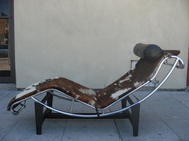 This tubular steel chaise lounge with an adjustable chrome cradle and matte black base is equipped with cowhide upholstery and a leather headset. Precision-crafted, this chaise is adjustable along the base from upright to full recline with ease,