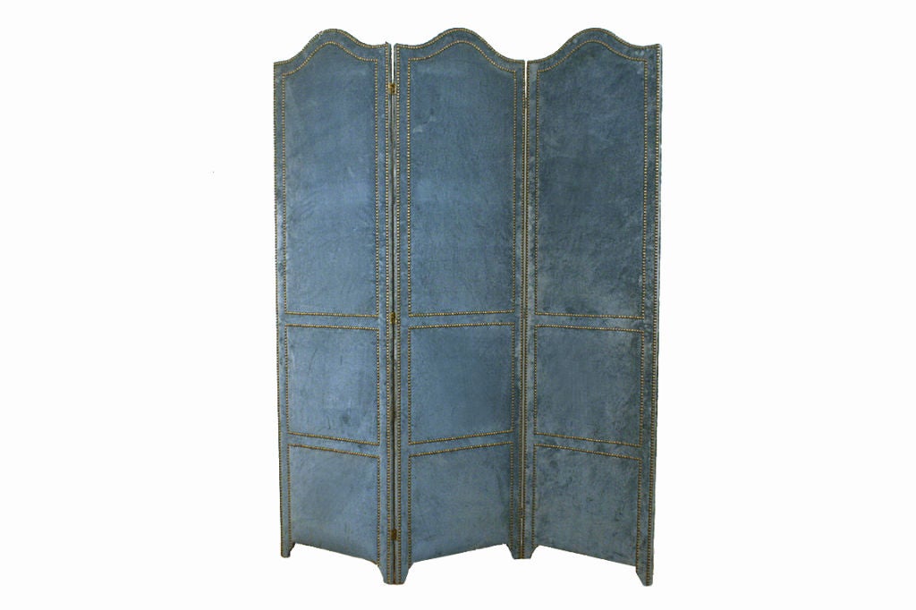 the three panels upholstered in light blue velvet and trimmed with brass nailheads, the panels connected by brass hinges, resting on small bracket feet, the reverse without nailheads