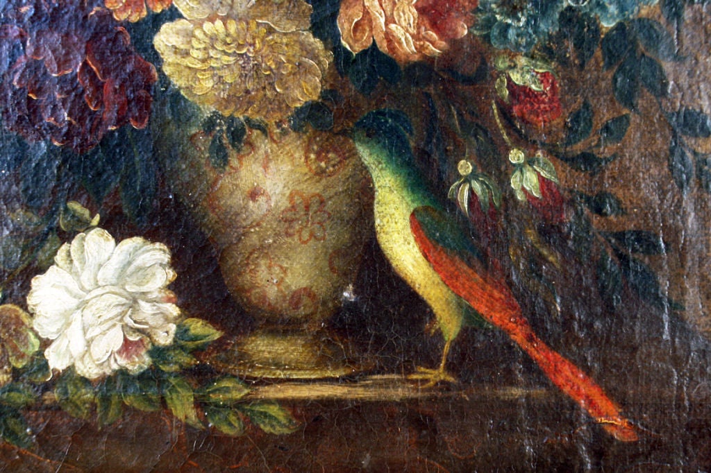 Depicting a Dutch pottery vase bursting with an array of flowers centered in a vaulted portico, with a stylized bird in the foreground, in a later antique giltwood and painted frame.

