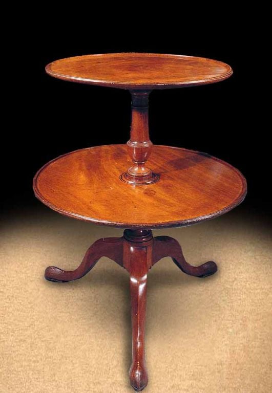 # G101 - Mid-Georgian mahogany two tiered dumbwaiter having a lovely warm honey color.  The two round tiers each with molded rims. Raised on a round tapering column and ending in graceful tripod legs with pad feet.
English, Mid 18th Century

See