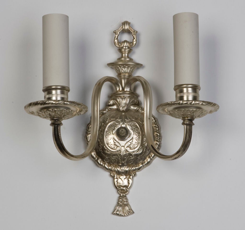 AIS2642
A pair of two arm antique sconces in their original silverplate finish. Having delicate and intricate foliate work in the backplate and bobeches. From a Rochester, New York estate. Circa 1910s.

Dimensions:
Overall: 11-3/8