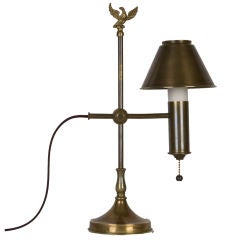 An antique single light desk lamp with eagle finial