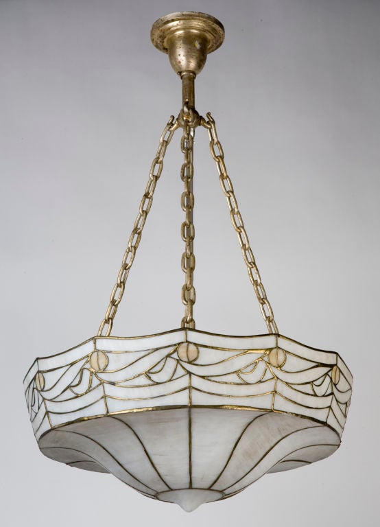 HL3492<br />
A delicately leaded antique art glass inverted dome chandelier with an incurving rosette. With opalescent white and amber accents, suspended by three chains. Due to the antique nature of this fixture there may be nicks or imperfections