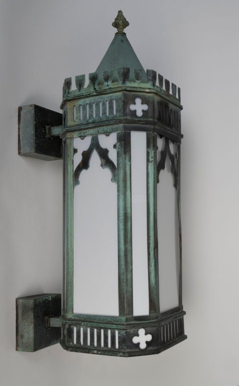 EX0565<br />
A pair of antique exterior wall lanterns in their original aged verdigris finish. Having gothic tracery pierced details. Glazed with cased glass panels.<br />
<br />
Backplate width: 5 1/8