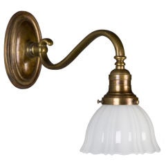 An antique bronze sconce with scalloped shade