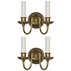 A pair of antique brass double-light round sconces