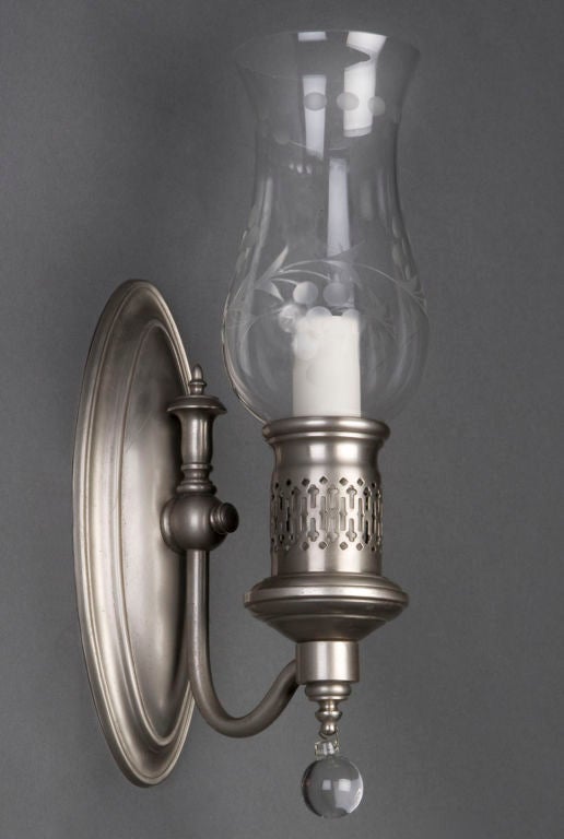 A pair of antique nickel hurricane sconces