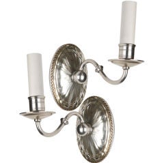 A pair of single light sconces with crystal backplate