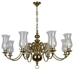 An eight-light solid brass chandelier with hurricane shades