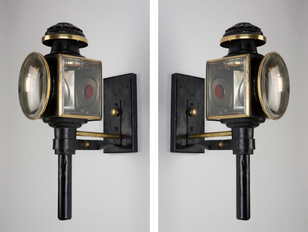 AEX0515<br />
An antique pair of carriage lights with beveled glass lenses finished in rich, crusty black enamel and polished brass.<br />
<br />
Backplate: 8